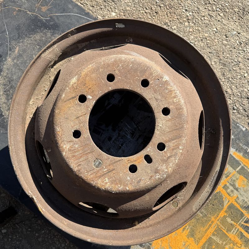 8-lug steel truck wheel before laser cleaning, covered in rust